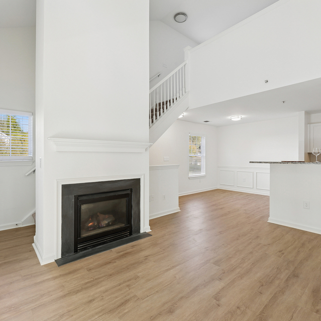 The Estates - Open Living Area With Fireplace And Wood Floors