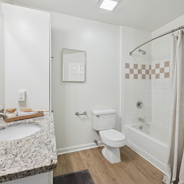 The Estates - Clean Bathroom With Shower Curtain And Vanity