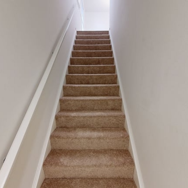 The Estates - Carpeted Staircase With White Walls