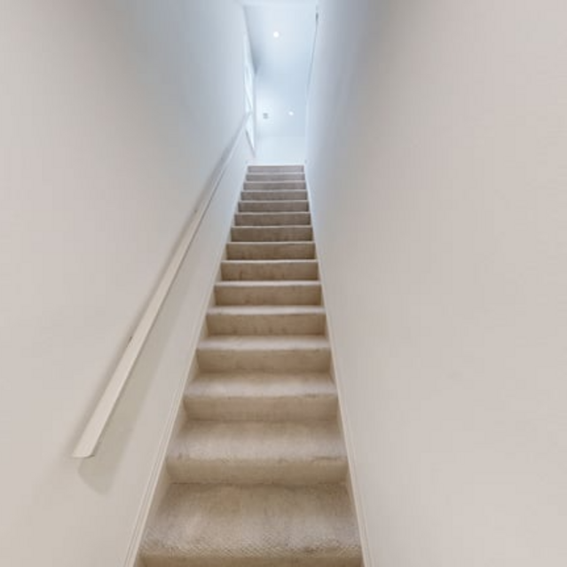 The Estates - Lighted Stairwell With Neutral Painted Walls